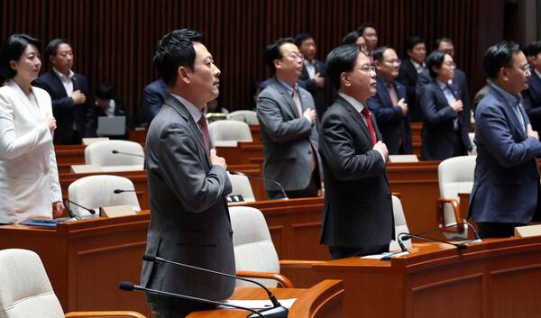 장동혁 대표와 송언석 원내대표를 비롯한 국민의힘 의원들이 9일 국회에서 열린 긴급 의원총회에서 국기에 경례하고 있다. 2026.3.9. 연합뉴스