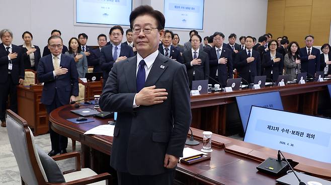 이재명 대통령이 지난달 30일 청와대에서 열린 수석보좌관회의에서 국기에 경례하고 있다. 연합뉴스