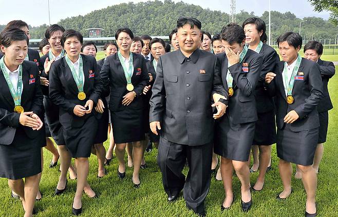 김정은 북한 국무위원장이 지난 2013년 동아시아연맹(EAFF) 축구선수권대회(동아시안컵)에서 우승한 여자 축구선수들을 만나 격려하고 있다. [연합뉴스 자료사진]