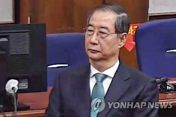 내란 중요임무 종사 혐의를 받는 한덕수 전 국무총리(왼쪽)가 21일 서울중앙지법에서 열린 1심 선고 공판에 출석해 있다. 연합뉴스