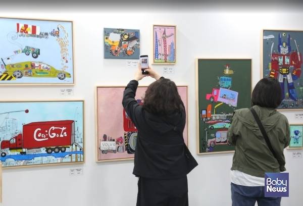 제6회 부산국제어린이청소년아트페어 전시장에서 한 관람객이 '영재발굴단' 출신 정인준 작가의 작품을 카메라에 담고 있다. 소장섭 기자 ⓒ베이비뉴스