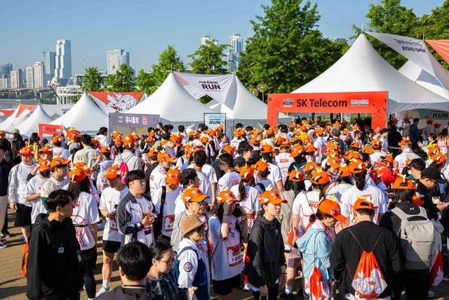 서울시 뚝섬한강공원에서 5일 열린 ‘포켓몬 런 2026 인 서울’ 행사 참가자들이 SK텔레콤과 삼성전자 공동부스에서 다양한 이벤트를 즐기고 있다. SKT 제공