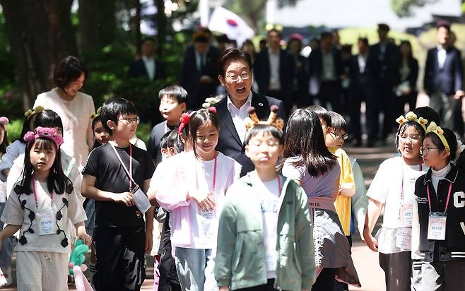 이재명 대통령과 김혜경 여사가 어린이날인 5일 청와대에서 열린 '2026년 104회 어린이날 청와대 초청행사'에서 참석 어린이들과 다양한 체험 활동을 위해 녹지원으로 이동하고 있다. 청와대사진기자단