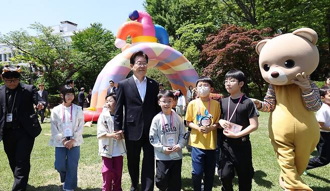 이재명 대통령과 김혜경 여사가 어린이날인 5일 청와대에서 열린 '2026년 104회 어린이날 청와대 초청행사'에서 참석 어린이들과 다양한 체험 활동을 위해 녹지원으로 이동하고 있다. 청와대사진기자단