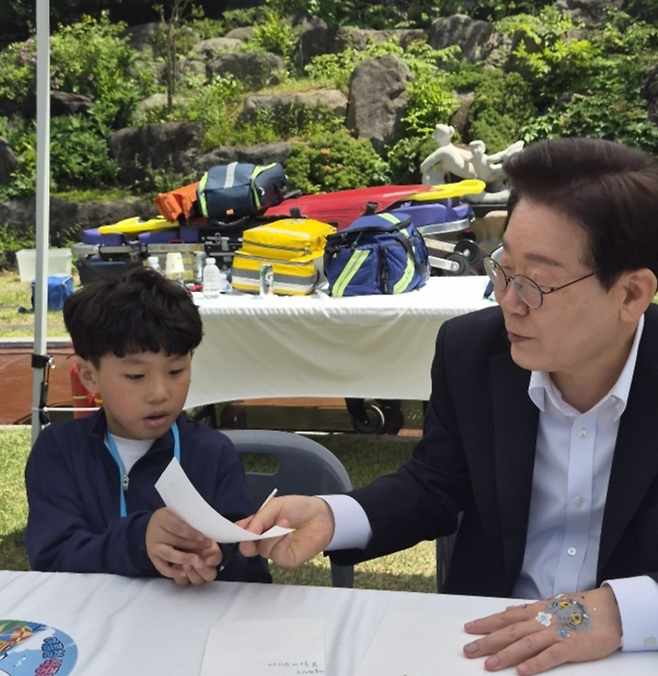 ▲ 이재명 대통령과 김혜경 여사는 5일 청와대에서 ‘2026년 제104회 어린이날 청와대 초청행사를 가진 가운데 이 대통령이 횡성초 3학년 허진수 군에게 메시지를 써주고 있다. 제공 횡성드림스타트