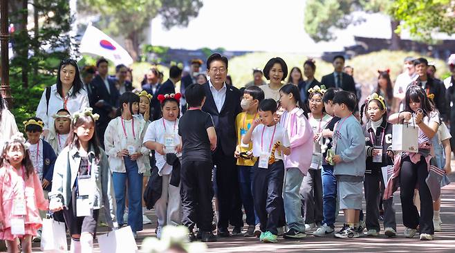 ▲ 이재명 대통령과 김혜경 여사가 5일 어린이날 초청행사 참석자들과 함께 청와대 녹지원으로 향하고 있다. 청와대통신사진기자단
