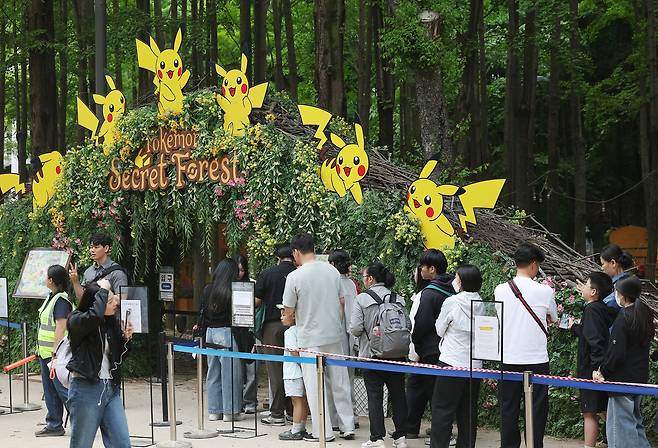 지난 2일 성동구 서울숲 ‘포켓몬 시크릿 포레스트’ 행사장 인근에서 시민들이 입장 대기열 등록을 기다리고 있다.  [연합]