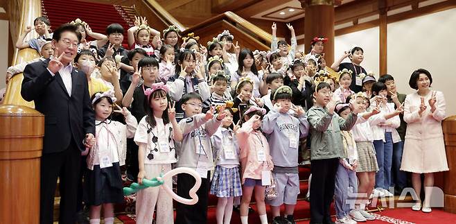 [서울=뉴시스] 최동준 기자 = 이재명 대통령과 김혜경 여사가 5일 청와대에서 열린 '2026년 제104회 어린이날 청와대 초청행사'에서 어린이들과 기념 촬영을 하고 있다. 2026.05.05. photocdj@newsis.com
