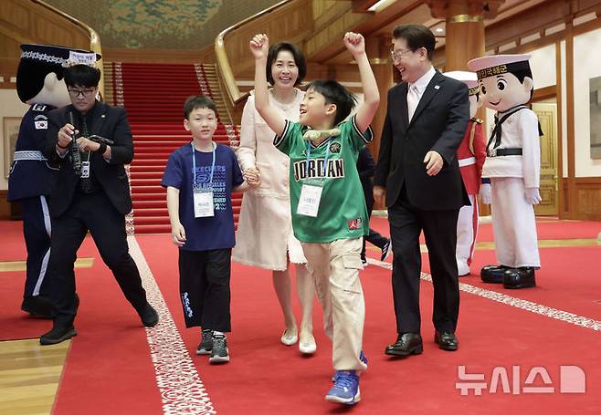 [서울=뉴시스] 최동준 기자 = 이재명 대통령과 김혜경 여사가 5일 청와대에서 열린 '2026년 제104회 어린이날 청와대 초청행사'에서 어린이들과 국무회의가 열리는 세종실로 향하고 있다. 2026.05.05. photocdj@newsis.com