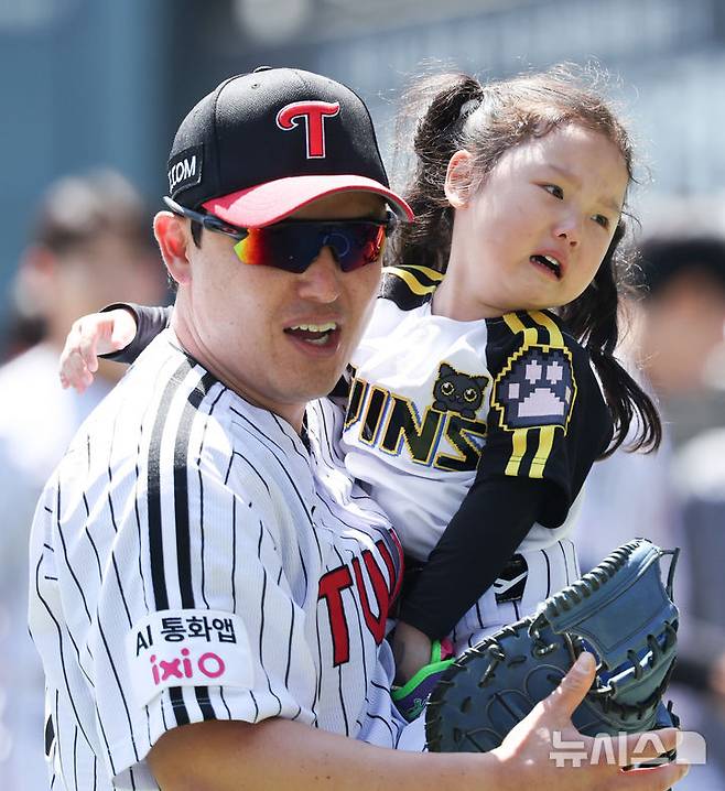 [서울=뉴시스] 최진석 기자 = 5일 서울 송파구 잠실야구장에서 열린 2026 KBO리그 두산 베어스와 LG 트윈스의 경기에서 LG 박동원과 딸 박채이 양이 시구 후 이동하고 있다. 2026.05.05. myjs@newsis.com