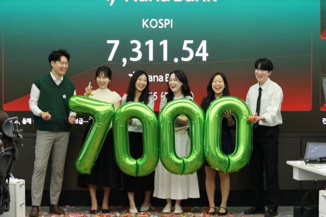 코스피가 7000을 돌파한 6일 서울 중구 하나은행 본점 딜링룸에서 직원들이 축하 세리모니를 하고 있다. [사진=연합뉴스]