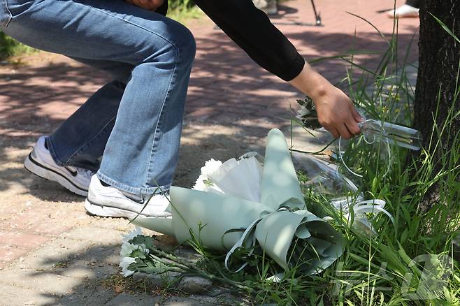 6일 오전 광주 광산구 남부대 인근 피습 현장을 찾은 한 시민이 국화꽃을 내려놓으며 고인의 넋을 기리고 있다. 2026.5.6 ⓒ 뉴스1 조수민 수습기자