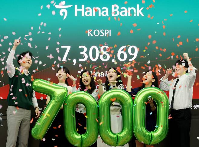 쿄스피가 장중 7천을 돌파한 6일 서울 중구 하나은행 본점 딜링룸에서 직원들이 축하 세리머니를 하고 있다. 연합뉴스