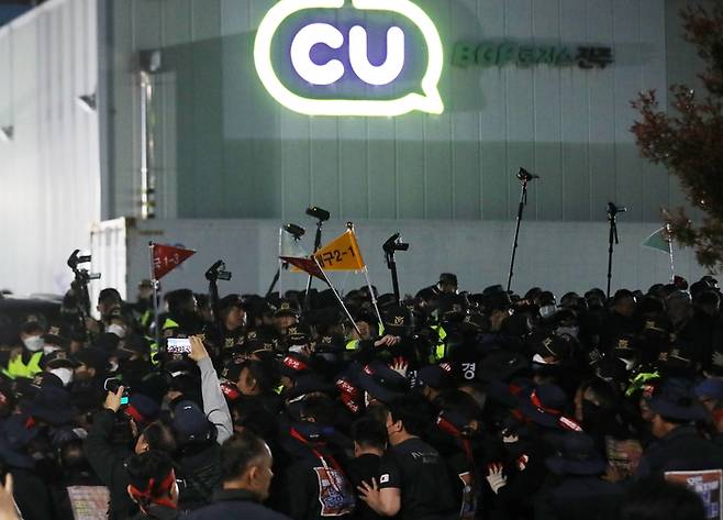 20일 경남 진주시 정촌면 CU 진주물류센터 앞에서 진입을 시도하는 화물연대 노조원들을 경찰이 막아서고 있다. [뉴스1]