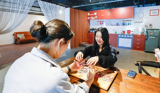 6일 서울 용산구 노들섬 노들갤러리에서 '해 지기 전에 들어와' 전시가 열린 가운데 시민들이 실뜨기 놀이 체험을 하고 있다.
