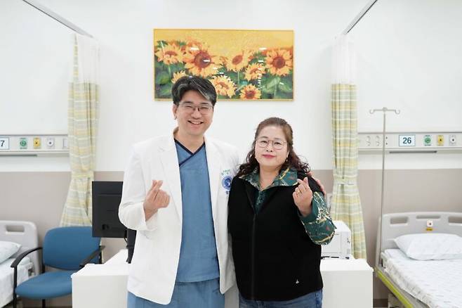 주치의 황상연 과장과 환자 홍씨. 이들의 뒤로 해바라기 액자가 보인다. 사진=동남권원자력의학원