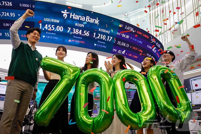 코스피가 7000을 돌파한 6일 서울 중구 하나은행 본점 딜링룸에서 직원들이 축하 세리모니를 하고 있다. 이날 코스피는 447.57포인트 오른 7,384.56에 장을 마감했다. (공동취재) 2026.5.6 ⓒ 뉴스1 박지혜 기자