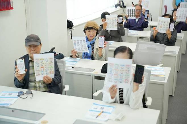서울 강서구 곰달래어르신복지센터에 마련된 AI디지털배움센터에서 수강생들이 인공지능(AI)으로 만든 이모티콘을 들어보이고 있다. 과학기술정보통신부