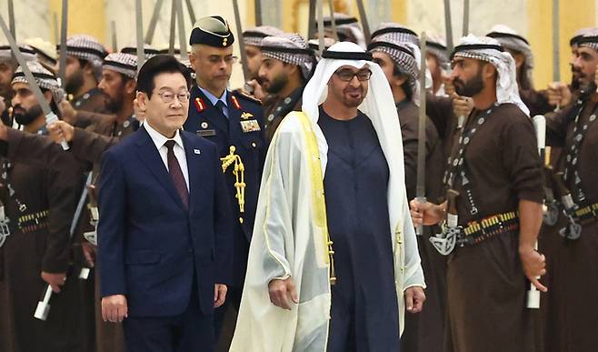 이재명 대통령이 지난해 11월 18일(현지시간) 아랍에미리트(UAE) 아부다비 대통령궁에서 열린 국빈방문 공식 환영식에서 무함마드 빈 자이드 알 나흐얀 UAE 대통령과 사열대로 이동하고 있다.  〈연합뉴스〉