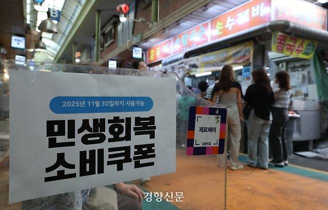 지난해 9월21일 서울 마포구 망원시장의 한 가게 입구에 소비쿠폰 관련 홍보물이 부착돼 있다. 권도현 기자