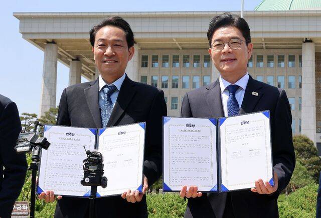더불어민주당 우상호 강원지사 후보와 정원오 서울시장 후보가 국회에서 강원·서울 상생협력 공동선언 서명식을 하는 모습. 연합뉴스