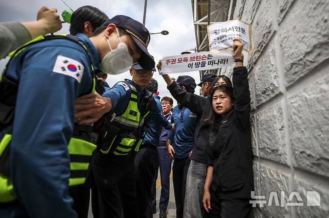 [서울=뉴시스] 정병혁 기자 = 7일 서울 종로구 주한미국대사관 앞에서 한국대학생진보연합 소속 대학생들이 전쟁반대 및 제이비어 브런슨 주한미군사령관 추방,  주한미군 철수 등을 촉구하며 기습시위를 하고 있다.  2026.05.07. jhope@newsis.com