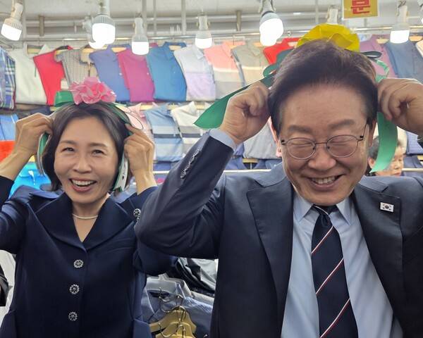이재명 대통령과 김혜경 여사가 8일 서울 남대문시장 한 상점에서 카네이션 머리띠를 착용해 보고 있다. 연합뉴스