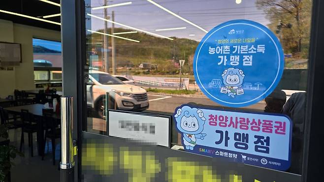 지난달 14일 충남 청양군 청양읍의 한 점포에 농어촌기본소득을 사용할 수 있는 '청양사랑상품권 가맹점' 스티커가 붙어 있다. 신진호 기자