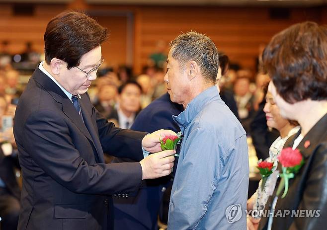 카네이션 달아드리는 이재명 대통령 (서울=연합뉴스) 한상균 기자 = 이재명 대통령이 8일 서울 중구 대한상공회의소에서 열린 어버이날 기념식에서 순직 소방관, 경찰관 부모님들에게 카네이션을 달아드리고 있다. 2026.5.8  [청와대통신사진기자단] xyz@yna.co.kr