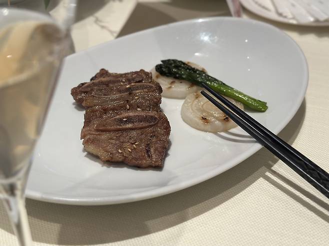Grilled marinated beef short ribs paired with Janseong-manri Lotus Leaf Yakju (Tammy Park/The Korea Herald)