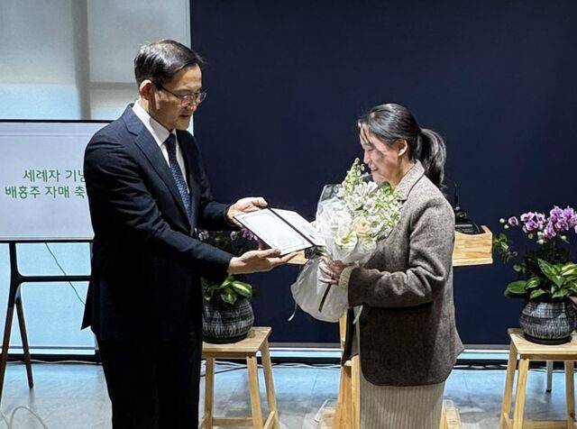 지난 2월 열린 첫 세례식에서 한 여성 성도에게 세례 증서를 전달하며 축하하고 있는 주 목사. 교회 제공
