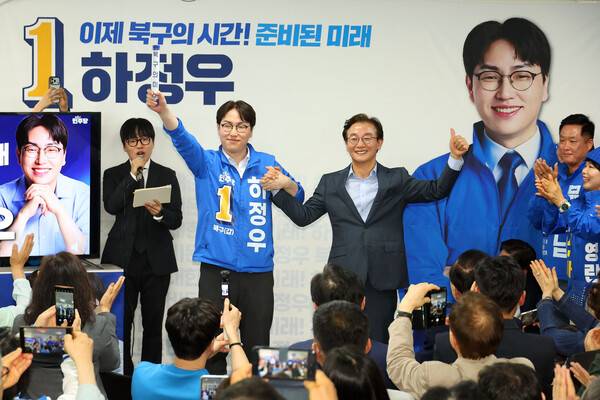 부산 북갑 국회의원 보궐선거에 출마하는 더불어민주당 하정우 후보가 10일 오후 부산 북구에서 열린 선거사무소 개소식에서 전재수 부산시장 후보가 건넨 '북구의 미래'가 적힌 바톤을 넘겨 받은 뒤 손을 잡고 있다. 연합뉴스