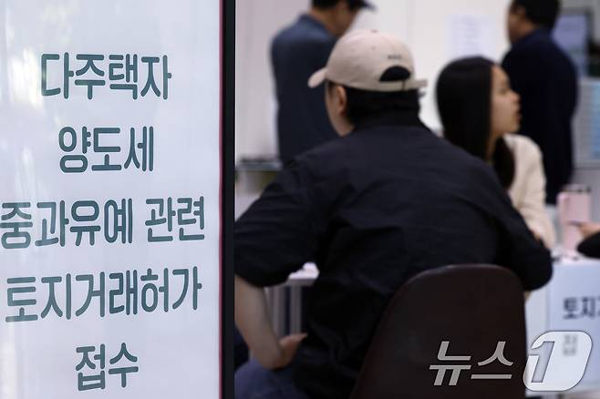 다주택자 양도소득세 중과 유예 종료 시한인 9일 오전 서울시 송파구 송파구청 1층에 마련된 다주택자 양도세 중과유예 관련 토지거래허가 접수처를 찾은 시민들이 부동산정보과 공무원들에게 서류 검토를 받고 있다. ⓒ 뉴스1 박정호 기자