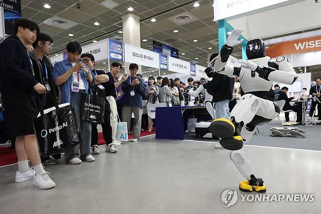 춤추는 로봇 (서울=연합뉴스) 강민지 기자 = 6일 서울 강남구 코엑스에서 열린 '국제인공지능대전'에서 참관객들이 로봇 시연을 살펴보고 있다. 2026.5.6 mjkang@yna.co.kr