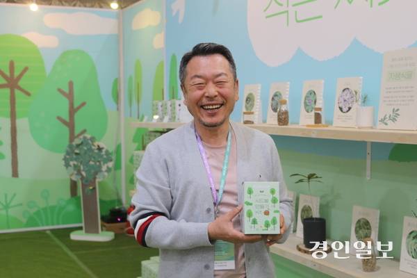 2026 고양국제꽃박람회에서 산불피해지역 복구 캠페인 부스를 운영하고 있는 (주)틔움세상 유계림 이사가 시드볼 키트를 들고 활짝 웃고 있다. 고양/김도란기자 doran@kyeongin.com