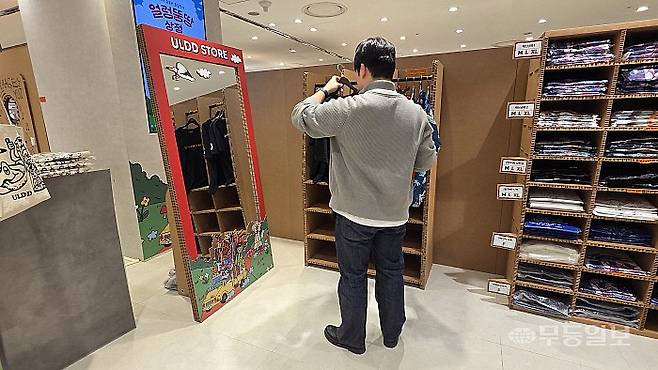 롯데백화점 광주점 4층 이벤트홀에 열린 ‘얼렁뚱땅 상점’ 팝업스토어에서 한 방문객이 티셔츠를 고르고 있다.