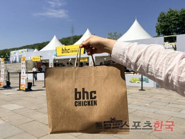 다이닝브랜즈그룹 치킨 브랜드 bhc가 9일 서울 난지한강공원에서 ESG 활동의 일환인 '별 하나 페스티벌'을 개최했다. F&B존 부스 앞에서 관객이 구매한 음식을 들고 있다. ⓒ김나연 기자
