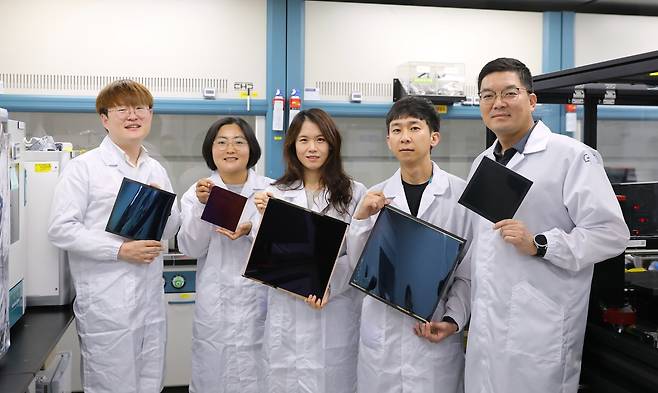 전남중(오른쪽 끝) 한국화학연구원 박사 연구팀이 개발한 페로브스카이트 태양전지 모듈을 들어보이고 있다.[한국화학연구원 제공]
