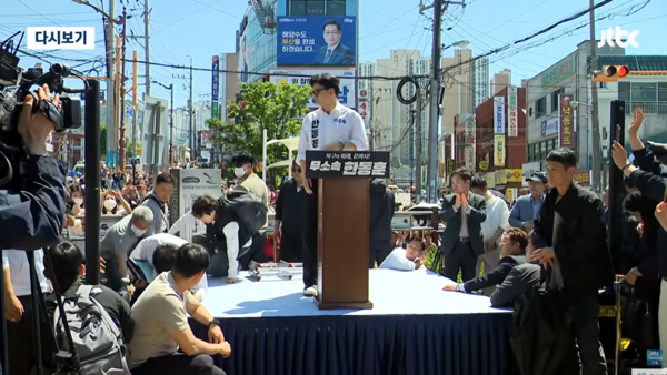 지난 9일 부산 북구 구포시장 인근 쌈지공원에서 열린 한동훈 후보 출마 기자회견을 촬영하던 방송사 카메라 기자가 뒷걸음치다 단상에서 떨어진 뒤 한동훈 예비후보가 기자 방향으로 고개를 돌리고 잠시 보는 모습. 2026.5.12. JTBC 보도화면 갈무리