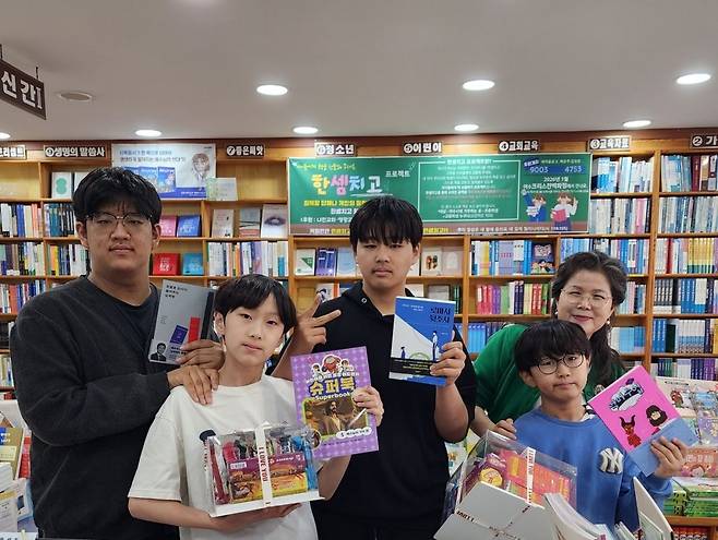김영희(맨 오른쪽) 전남 여수 크리스챤백화점 대표가 지난 4일 ‘한 셈 치고’ 캠페인으로 매장을 찾은 어린이와 청소년에게 책과 어린이날 선물을 전한 뒤 기념사진을 찍고 있다. 여수 크리스챤백화점 제공