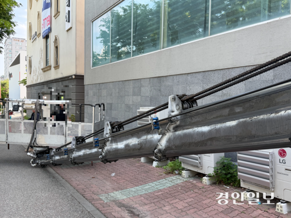 집단 식중독 신고가 들어온 매장 앞에서 철거 업체 직원들이 건물 외벽에 붙은 간판을 떼고 있다. 2026.05.13 /마주영기자 mango@kyeongin.com