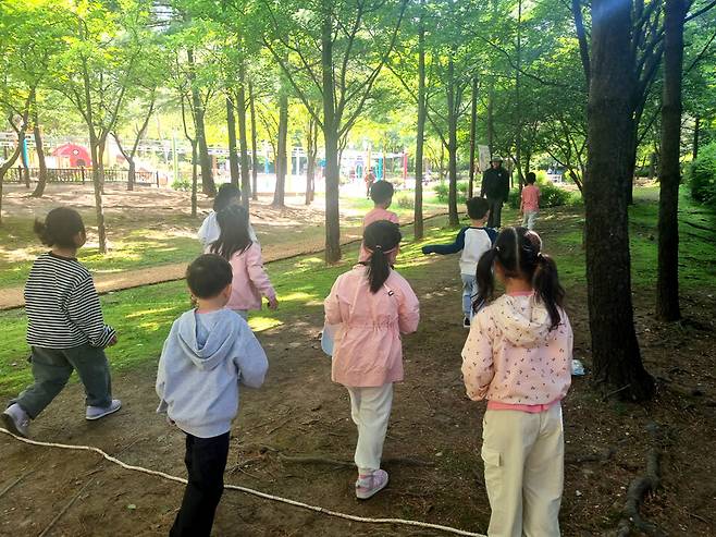 ▲ 민백초등학교 학생들이 민백공원에서 '숲에서 배우는 생태계' 수업을 듣고 있다. /사진제공=민백초등학교