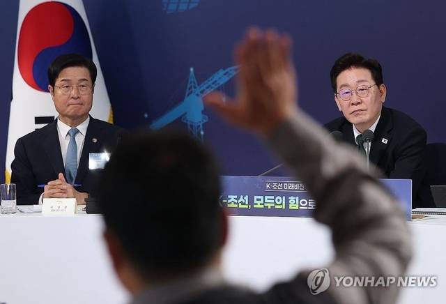 이재명 대통령이 13일 호텔현대 바이 라한 울산에서 열린 K-조선 미래비전간담회에서 참석자들의 발언 요청을 받고 있다. 왼쪽은 이상균 HD현대중공업 대표이사. 연합뉴스