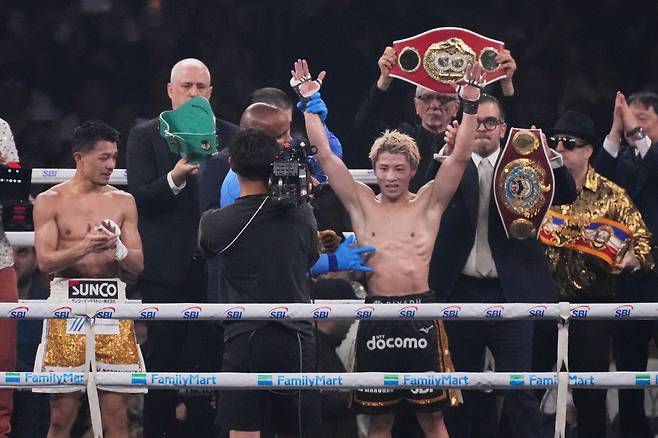 지난 2일 일본 도쿄돔에서 열린 프로복싱 슈퍼밴텀급 WBC, WBC, IBF, WBO 4개 기구 통합 타이틀전에서 승리한 ‘몬스터’ 이노우에 나오야가 승리 후 손을 번쩍 들어올리고 있다. 옆에서 박수를 쳐주는 이는 이번 경기에서 판정패한 나카타니 준토. [AP]