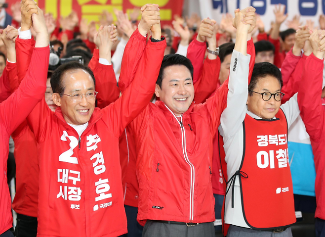 장동혁(앞줄 가운데) 국민의힘 대표가 12일 대구 수성구 국민의힘 당사에서 열린 경북도당 선거대책위 발대식에서 추경호(왼쪽) 대구시장 후보, 이철우 경북지사 후보와 함께 손을 들어올린 모습. 대구 뉴스1
