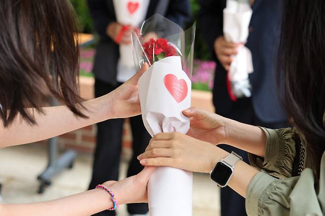 서울 노원구의 한 초등학교에서 선생님이 학생들에게 꽃을 선물받고 있다. 뉴스1