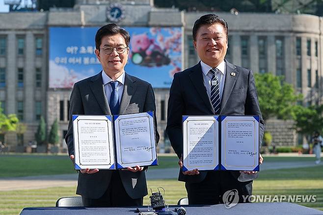 정원오 후보, 신용한 후보와 서울-충북 상생 협약식 (서울=연합뉴스) 서대연 기자 = 더불어민주당 정원오 서울시장 후보(왼쪽)가 13일 서울 중구 서울특별시청 앞에서 열린 서울-충북 상생 협약식 "대한민국의 미래를 함께 열겠습니다"에서 신용한 충북도지사 후보와 협약서에 사인한 뒤 기념사진을 찍고 있다. 2026.5.13 dwise@yna.co.kr