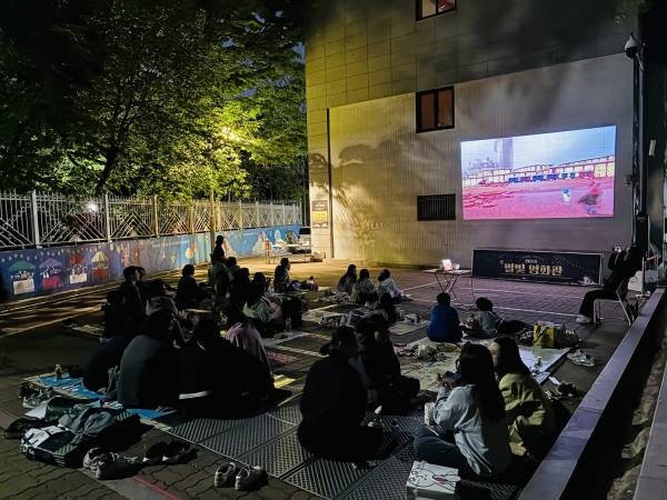 도화청소년문화의집 '별빛 영화관'에 참여한 청소년과 주민들이 야외에서 영화를 관람하고 있다.&nbsp;ⓒ마포구