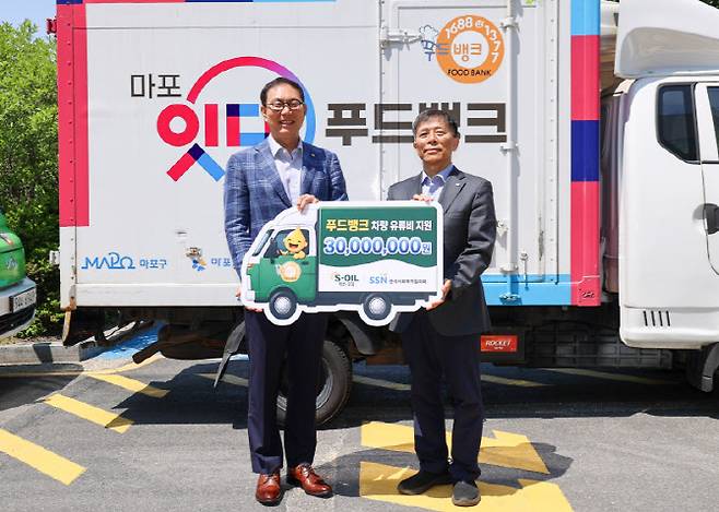 14일 서울 마포푸드뱅크 1호점에서 개최된 농어촌 지역 식품나눔 차량 유류비 전달식에서 이건명 에쓰오일 본부장(왼쪽)과 조남권 한국사회복지협의회 사무총장이 기념 촬영을 하고 있다.(사진=에쓰오일 제공)