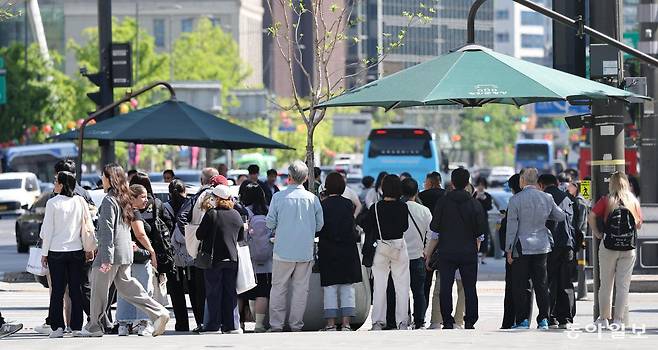 지난달 24일 서울 낮 최고기온이 26도까지 오른 가운데 서울 종로구 세종대로사거리 횡단보도에서 시민들이 햇볕을 피해 그늘막 아래에 모여 보행신호를 기다리고 있다. 서울시는 15일부터 10월 중순까지 폭염, 수방, 안전, 보건 등 4개 분야를 중심으로 한 ‘2026년 여름철 종합대책’을 시행한다고 13일 밝혔다. 이한결 기자 always@donga.com